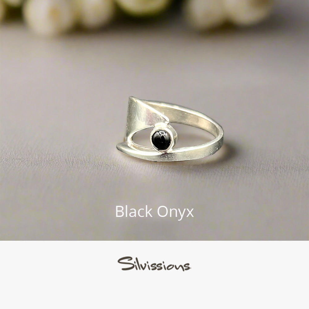 Silver ring with black onyx stone on a gray background, branded 'Silvissions'.