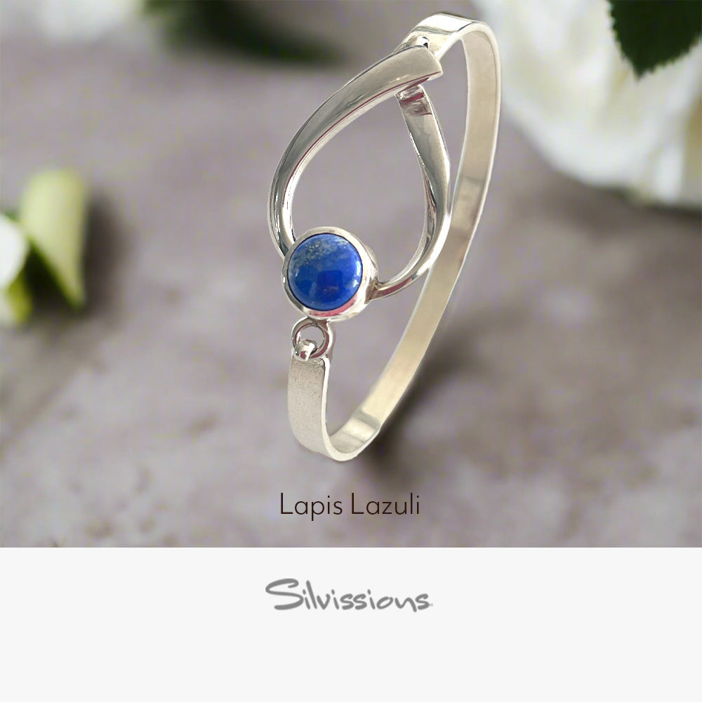 Silver bangle with a blue gemstone on a neutral background, featuring the brand 'Silvissions'.