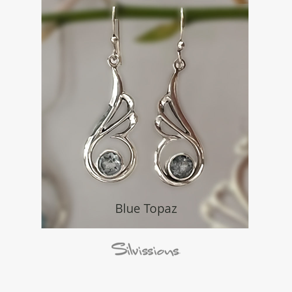 Silver earrings with blue topaz stones on a neutral background, branded 'Silvissions'.