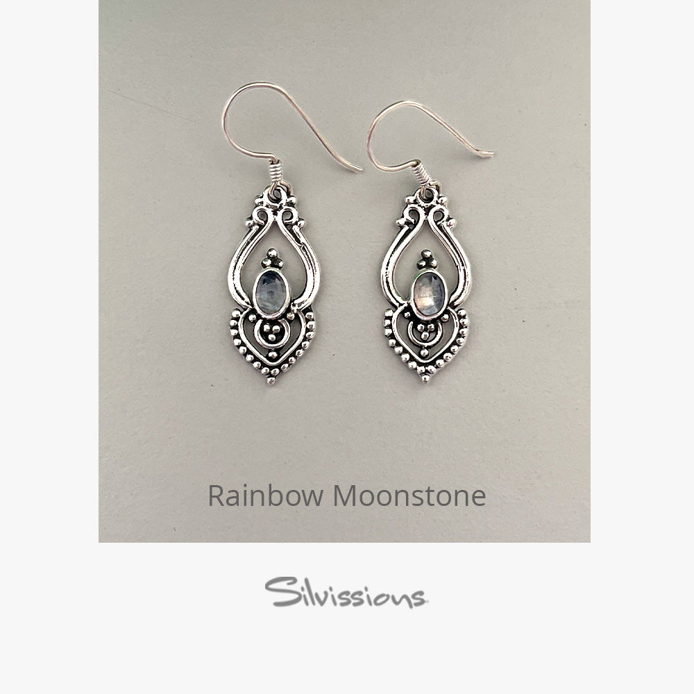 Silver earrings with rainbow moonstone stones on a gray background, branded 'Silvissions'.