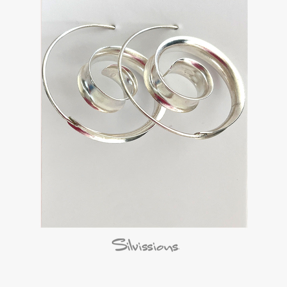 Silver spiral earrings on a light gray background with 'Silvissions' branding.