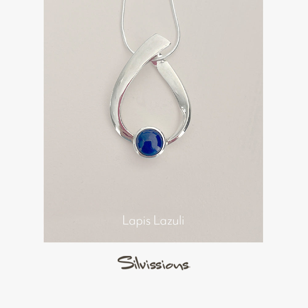 Silver pendant with lapis lazuli stone on a beige background, featuring the brand 'Silvissions'.