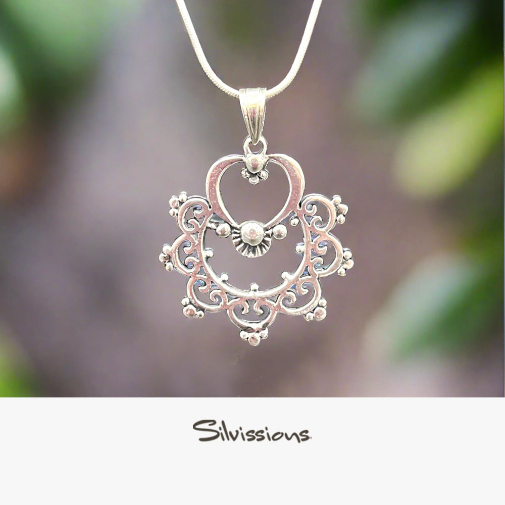 A sterling silver necklace with a handcrafted delicately detailed pendant, displayed against a natural background with the brand name 'Silvissions' visible.