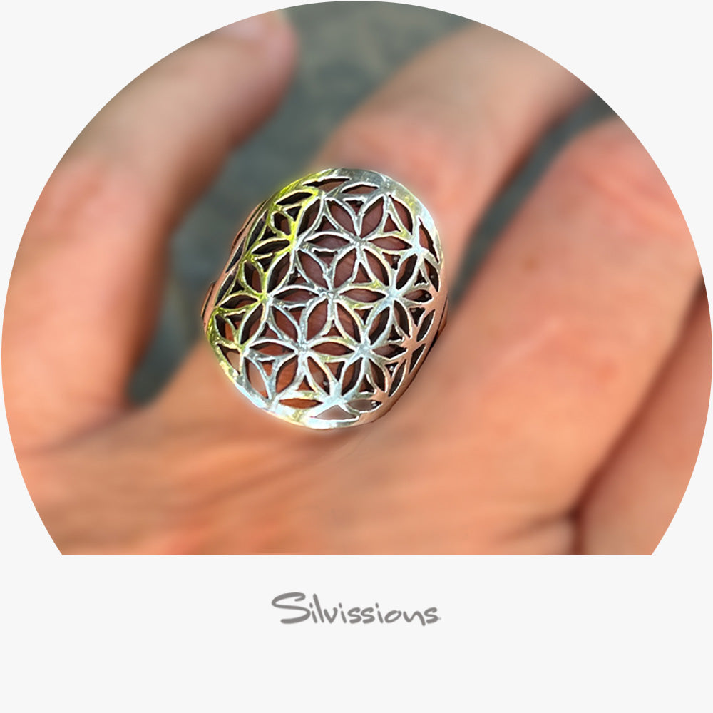 Silver ring with intricate design held in a hand, branded 'Silvissions Jewelry'.