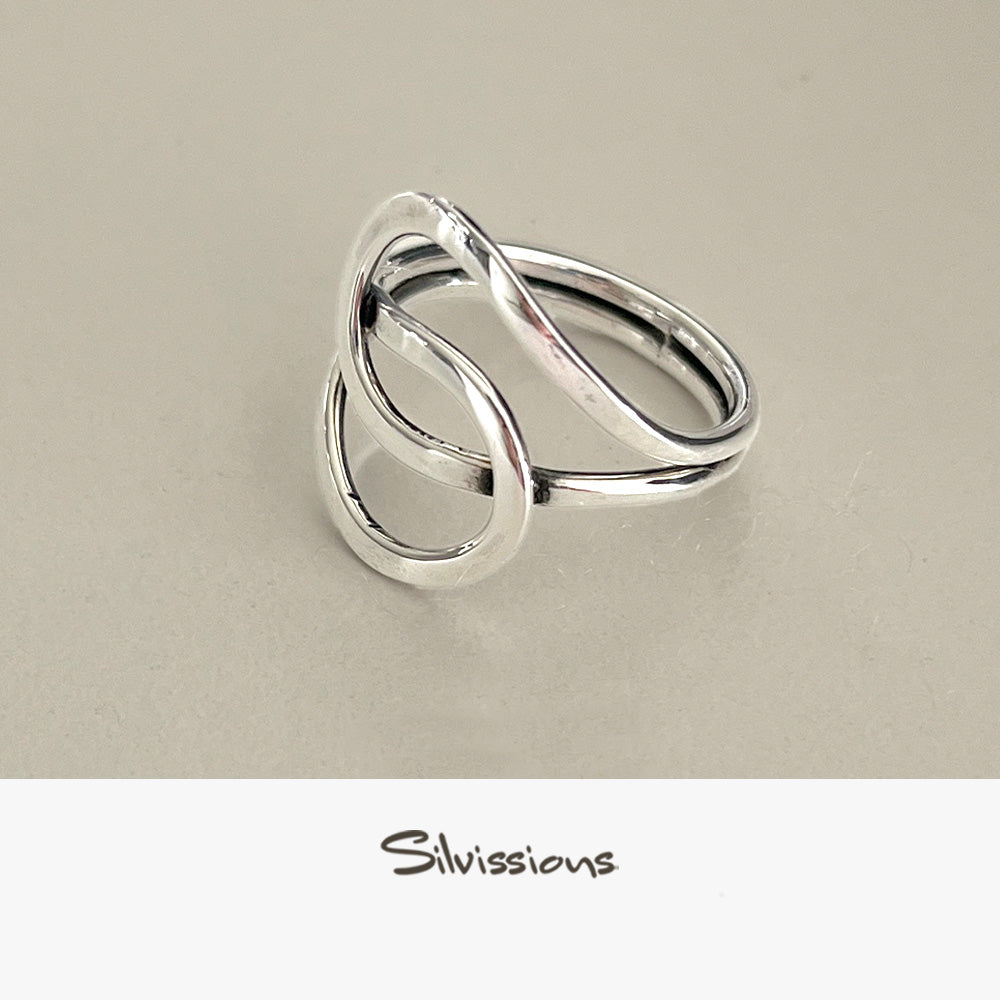 A sterling silver ring with an intricate endless knot design, displayed on a light background with a text mentioning the artisan jewelry crafted with genuine sterling silver and gemstones.
