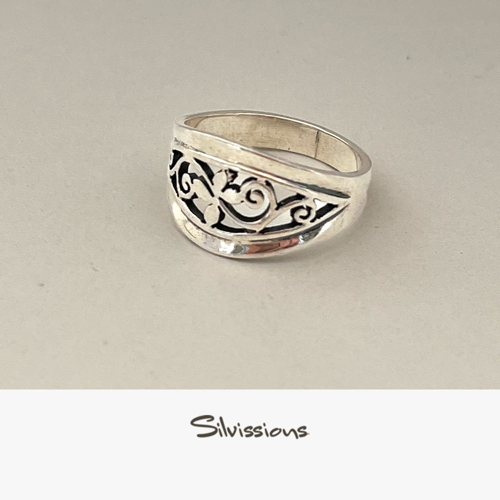 Silver ring with intricate design on a light gray background, branded 'Silvissions'.