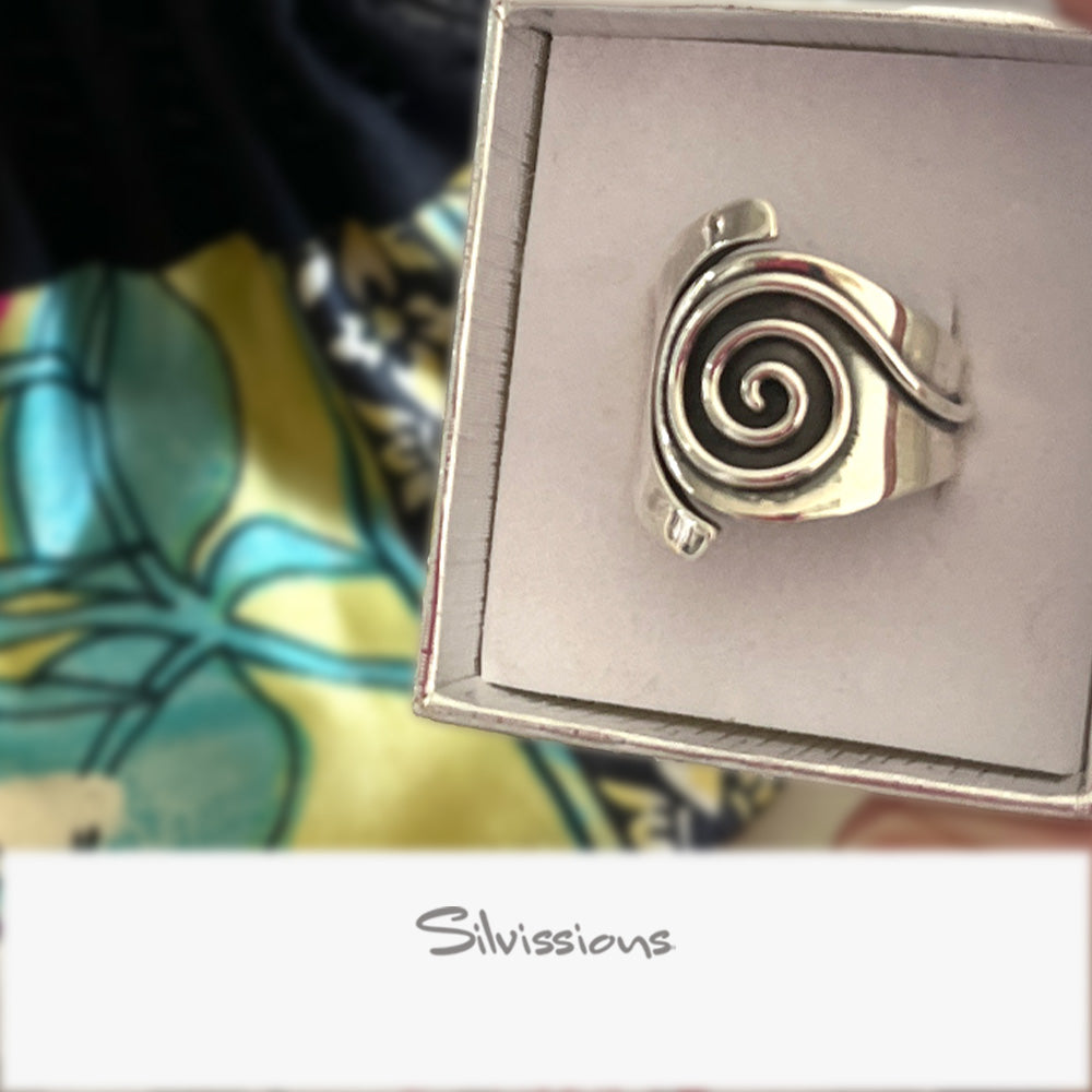 Silver ring with a spiral design on a Silvissions branded box.