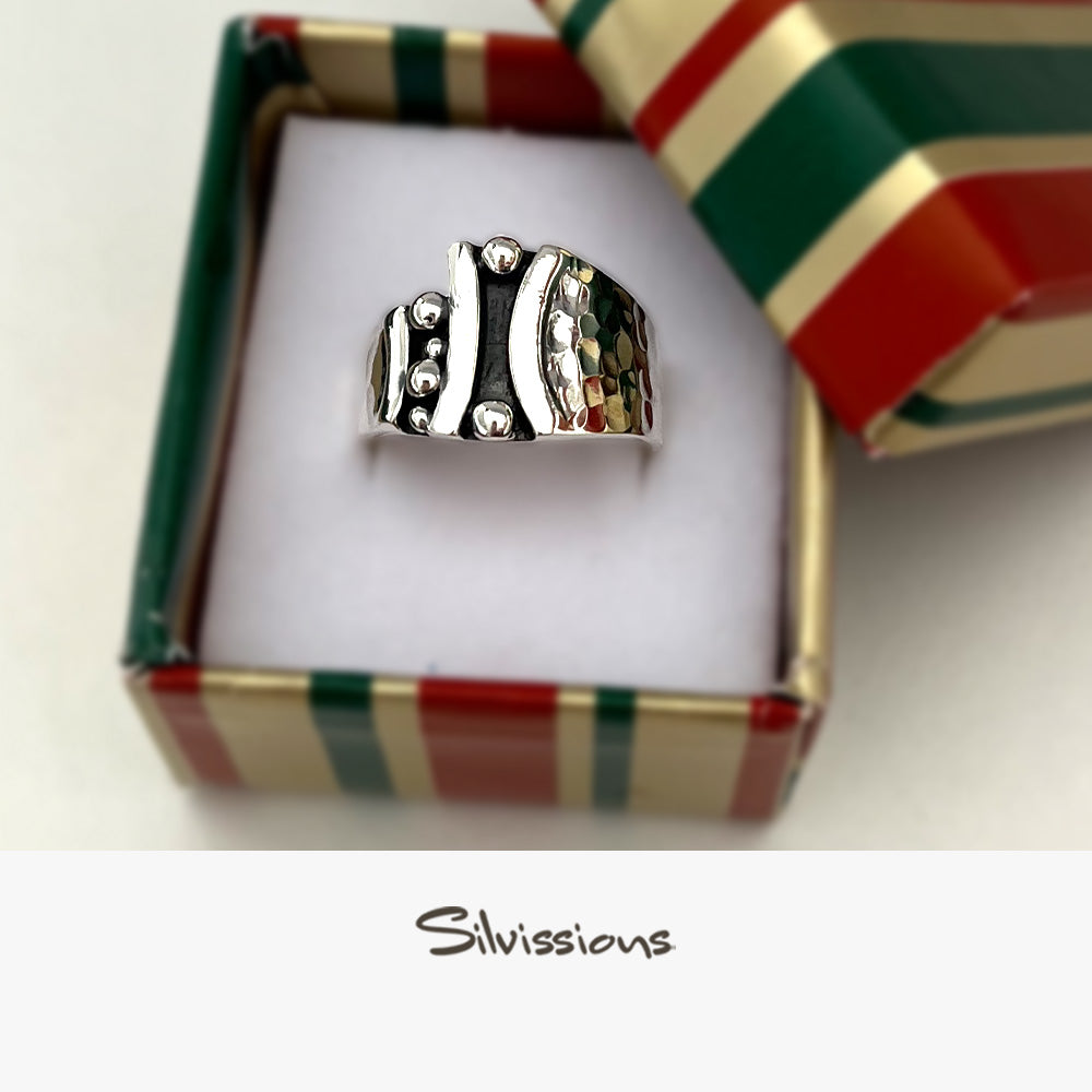 Silver ring in a decorative wrapped box with a colorful ribbon, featuring the brand 'Silvissions'.