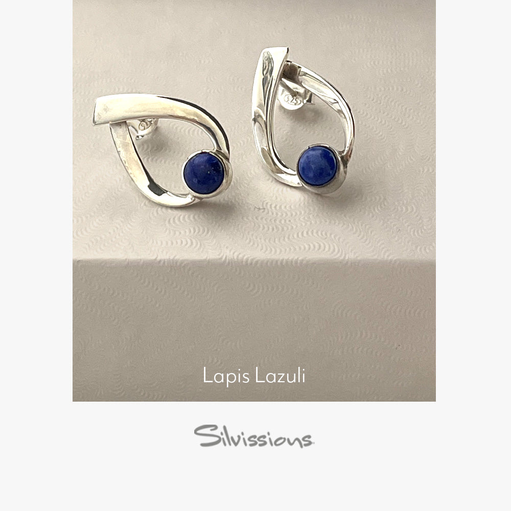 Silver earrings with blue gemstones on a beige background, branded 'Silvissions'.