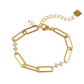 Gold bracelet with chain links and decorative charms on a white background