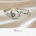 Silver bracelet with amethyst stone on a soft beige background, featuring the brand 'Silvissions'.