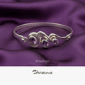 Silver bracelet with amethyst stones on a purple fabric background, featuring the brand 'Silvissions'.