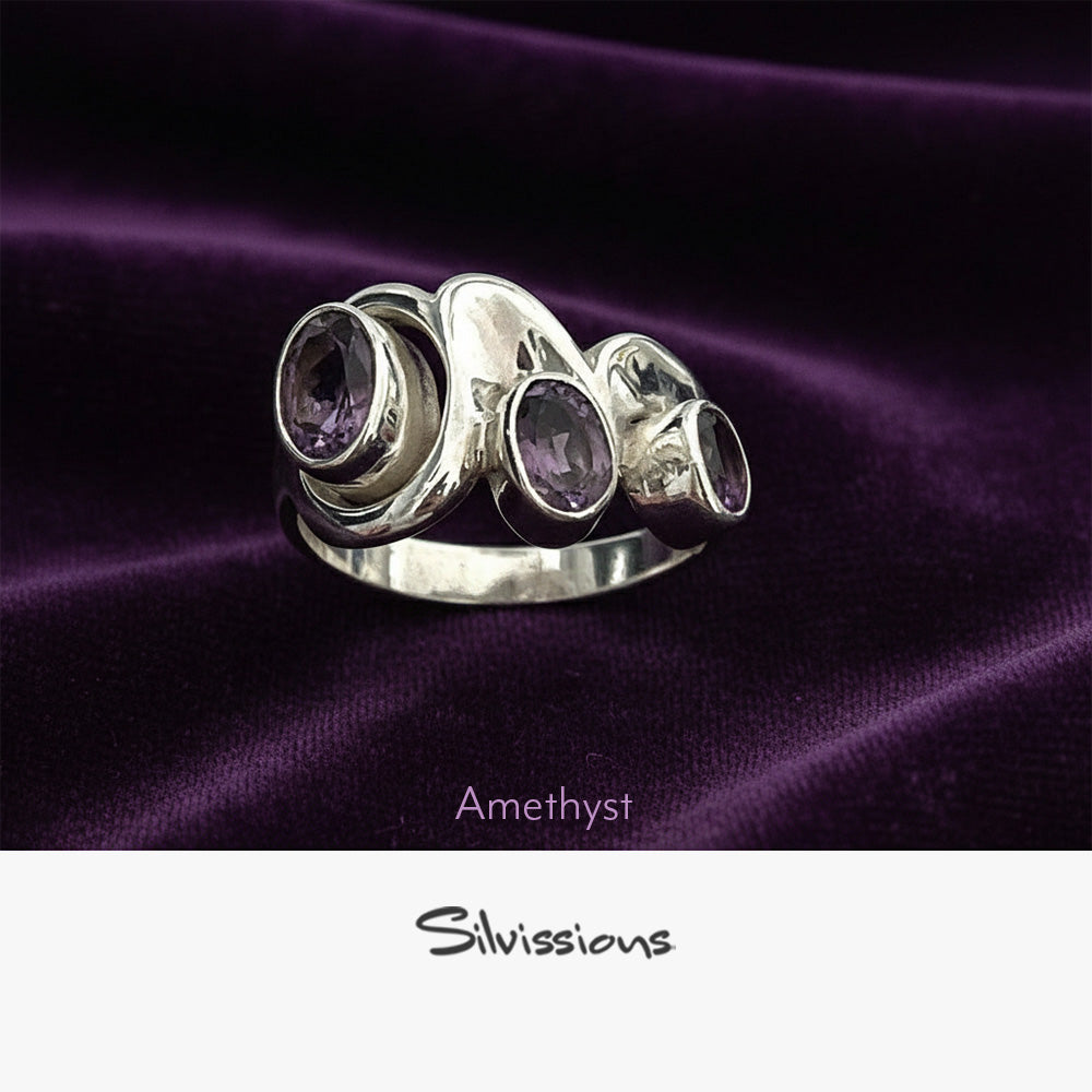 Silver ring with amethyst stones on purple fabric, featuring the brand 'Silvissions'.