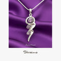 Silver pendant with amethyst stones on a purple satin background, featuring the brand 'Silvissions'.