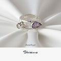 Silver ring with amethyst stone on white fabric, featuring the brand 'Silvissions'.
