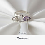 Silver ring with amethyst stone on white fabric, featuring the brand 'Silvissions'.