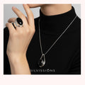 Person wearing a black ring and necklace with 'SILVISSION' branding.