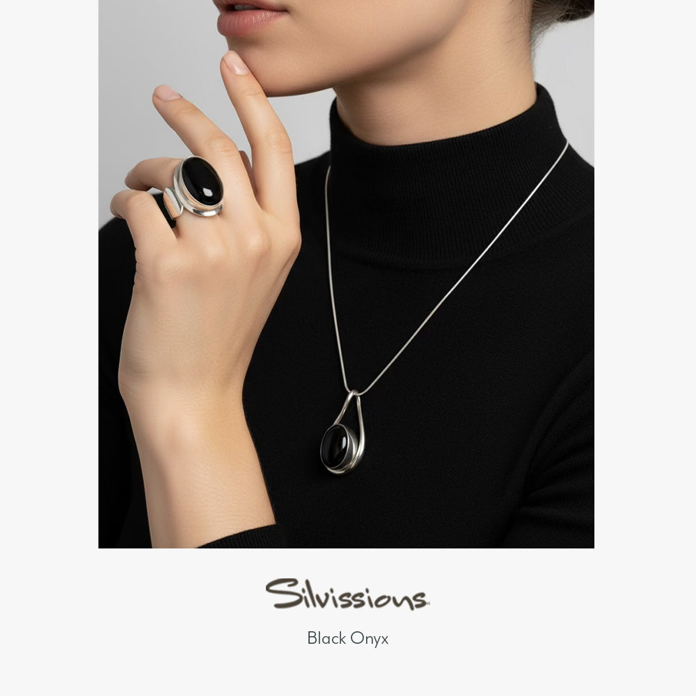 Woman wearing a black onyx ring and necklace with 'Silvissions' branding.