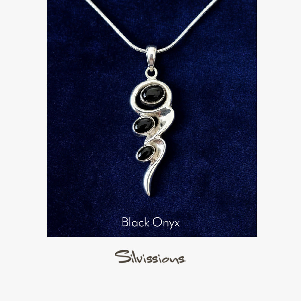 Silver pendant with black onyx stones on a dark blue background