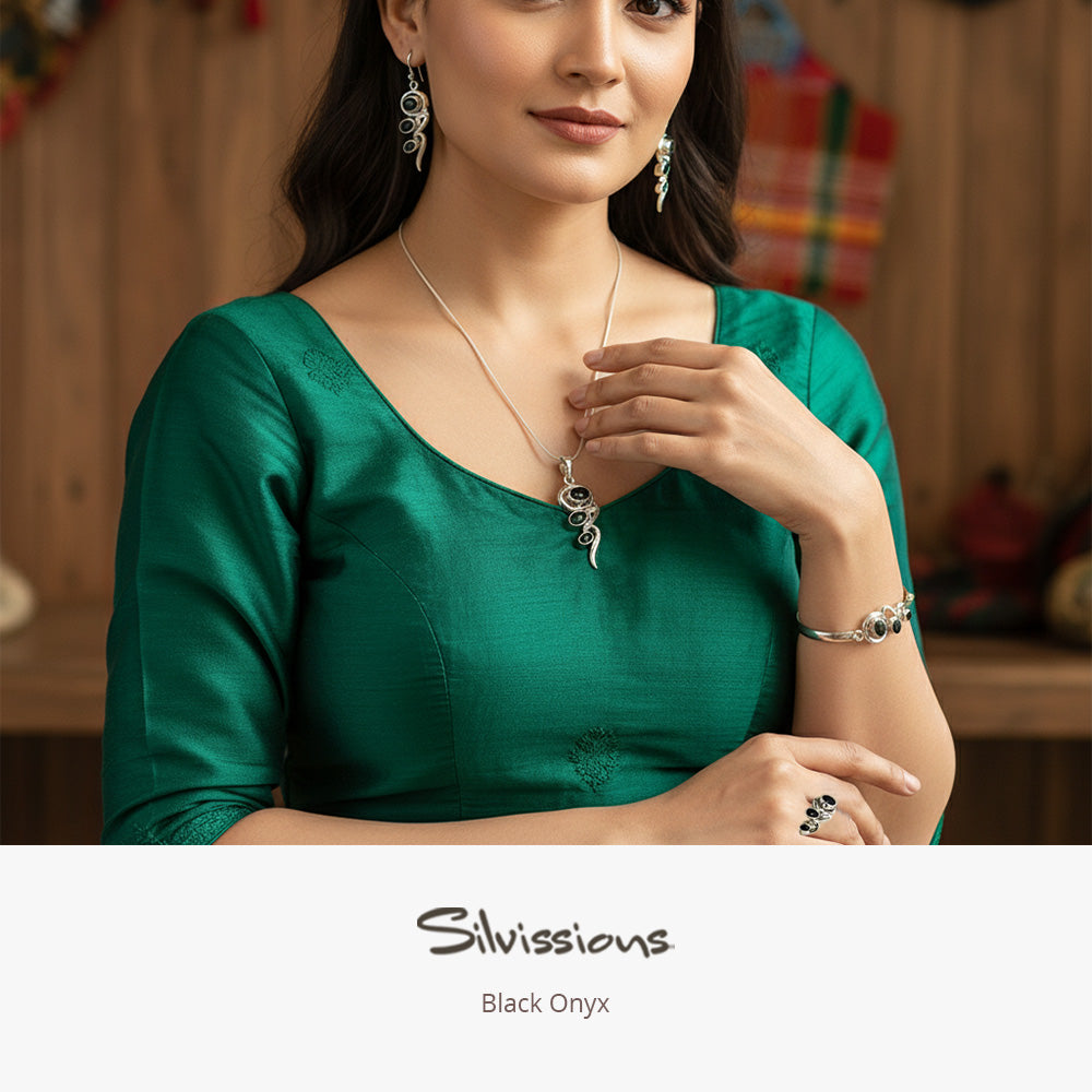 Woman in a green dress wearing black onyx gemstone jewelry with 'Silvissions' branding