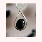 Silver pendant with black onyx stone on a blurred background, featuring the brand 'Silvissions'.