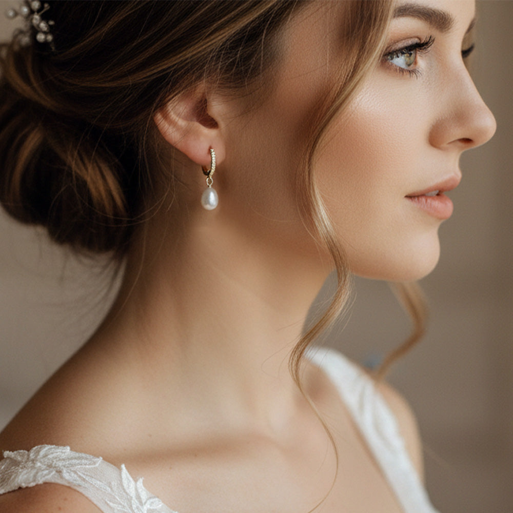 Close-up of a woman wearing pearl earrings with a blurred background