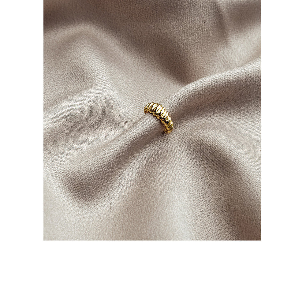 Cuff earring on a soft beige fabric background