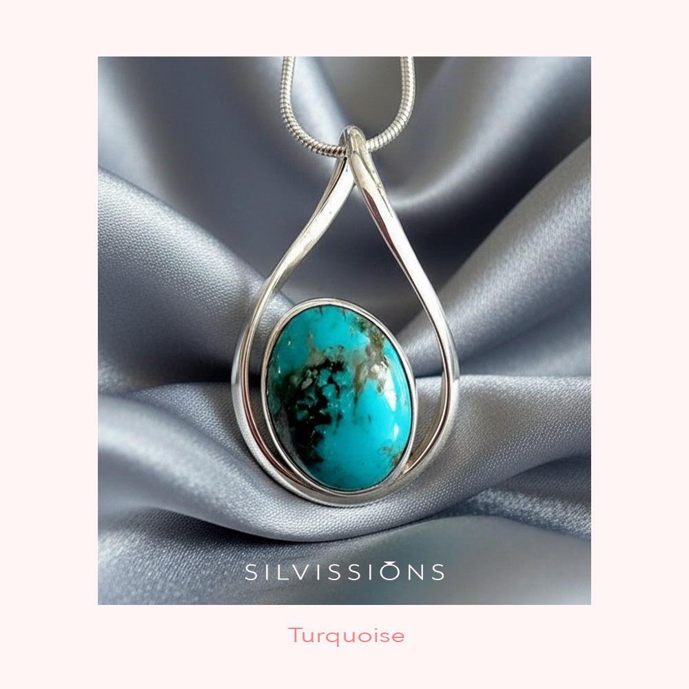 Silver pendant with turquoise stone on a silver fabric background, featuring the brand 'Silvissions'.