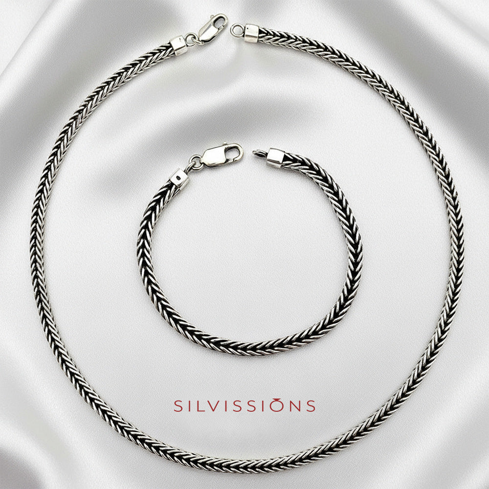 Silver necklace and bracelet set on a satin surface with 'Silvissions' branding.