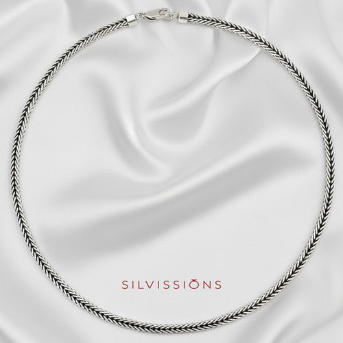 Silver necklace on a satin background with 'Silvissions' branding.