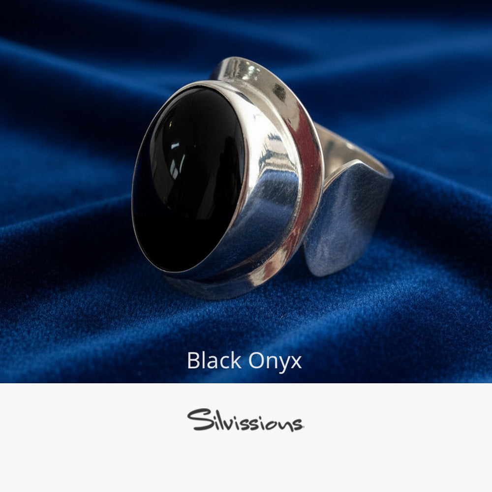 Silver ring with black onyx stone on blue fabric, featuring the brand 'Silvissions'.