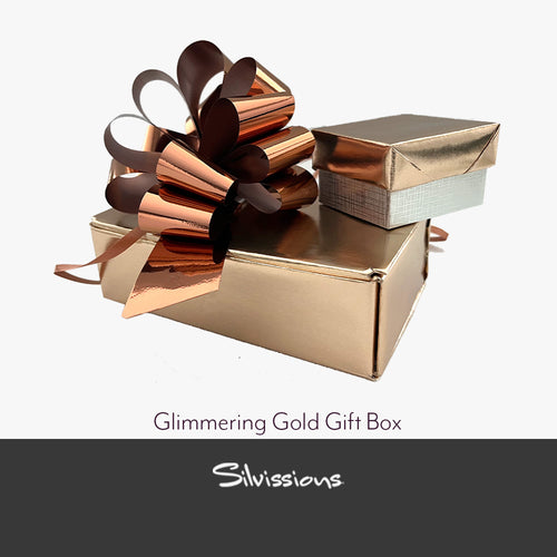 Glimmering gold gift box with a decorative bow on a white background, featuring the brand 'Silvissions'.
