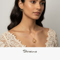 Woman wearing gold jewelry with a neutral background, featuring the brand 'Silvissions'.