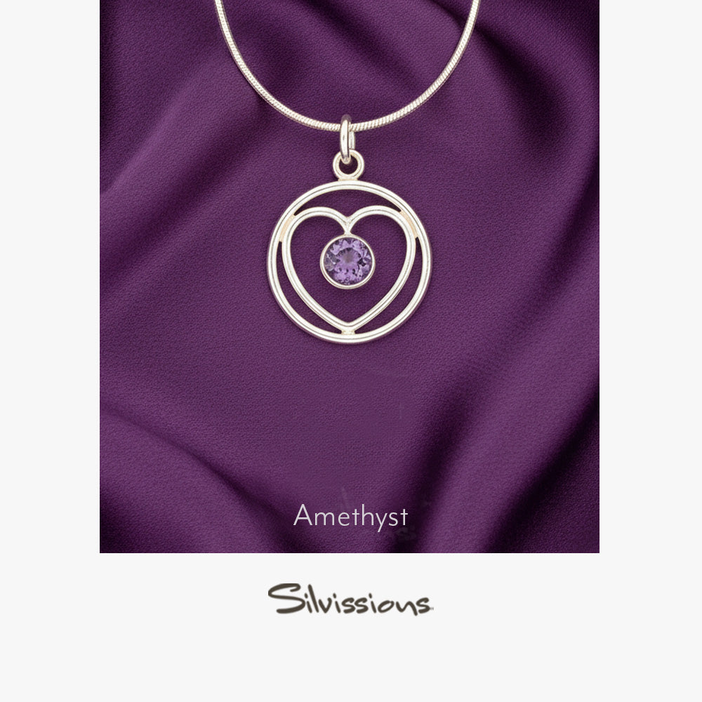 A sterling silver heart-shaped pendant necklace with an amethyst gemstone in the center, displayed against a purple background with the brand name 'Silvissions' mentioned at the bottom.