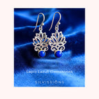 Silver earrings with blue stones on a blue satin background, featuring the brand 'Silvissions'.