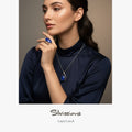 Woman wearing blue gemstone jewelry with 'Silvissions' branding