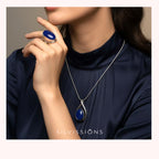 Person wearing a blue gemstone ring and pendant with 'Silvissions' branding.