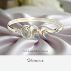 Silver bracelet with rainbow moonstone stones on a soft fabric background, featuring the brand 'Silvissions'.