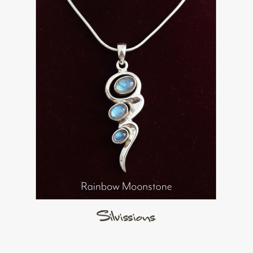 Silver pendant with rainbow moonstone stones on a dark background, branded 'Silvissions'.