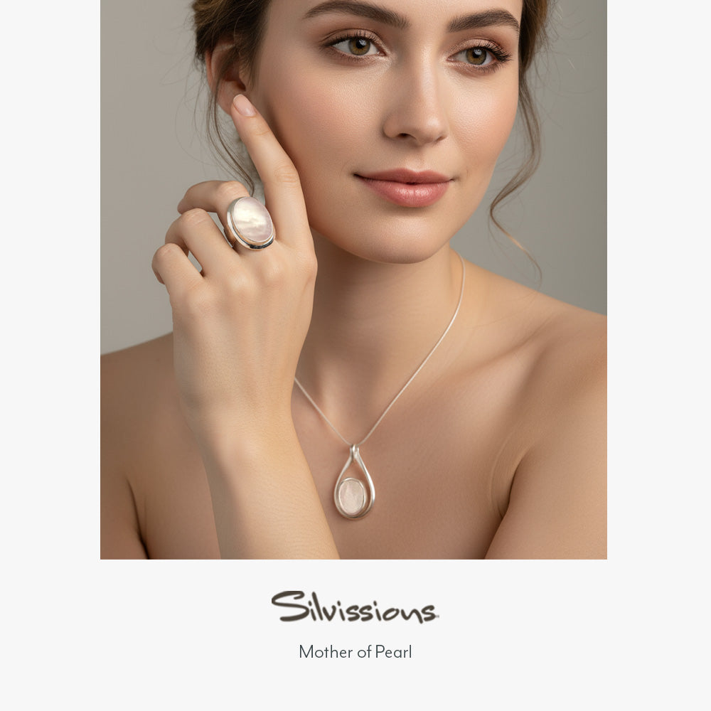 Woman wearing a silver mother of pearl necklace and ring with 'Silvissions' branding.
