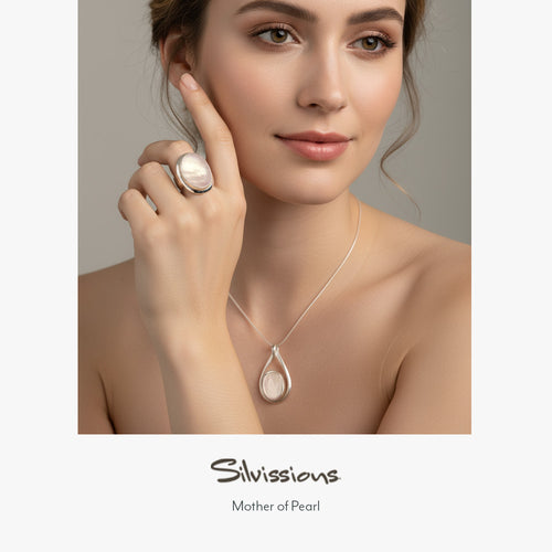 Woman wearing a silver mother of pearl necklace and ring with 'Silvissions' branding.