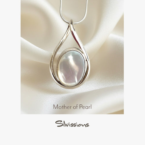 Teardrop-shaped pendant with mother of pearl on a white satin background, branded 'Silvissions'.