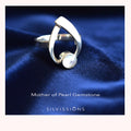 Silver ring with a pearl on a blue fabric background, featuring the brand 'Silvissions'.