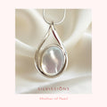 Silver pendant with a mother of pearl stone center on a soft fabric background, branded 'Silvissions'.