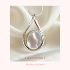 Silver pendant with a mother of pearl stone center on a soft fabric background, branded 'Silvissions'.