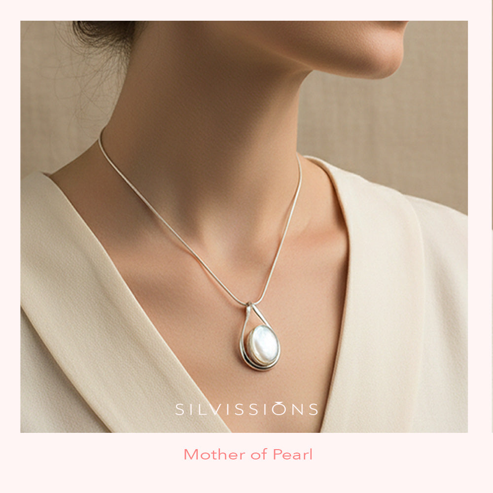 Necklace with a mother of pearl stone pendant worn by a person, brand 'Silvissions' visible