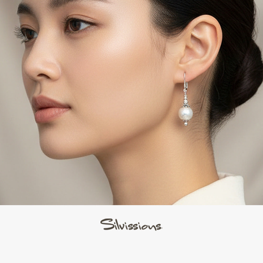 Close-up of a woman wearing pearl earrings with 'Silvissions' branding.