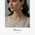 Woman wearing silver necklace and earrings with 'Silvissions' branding.
