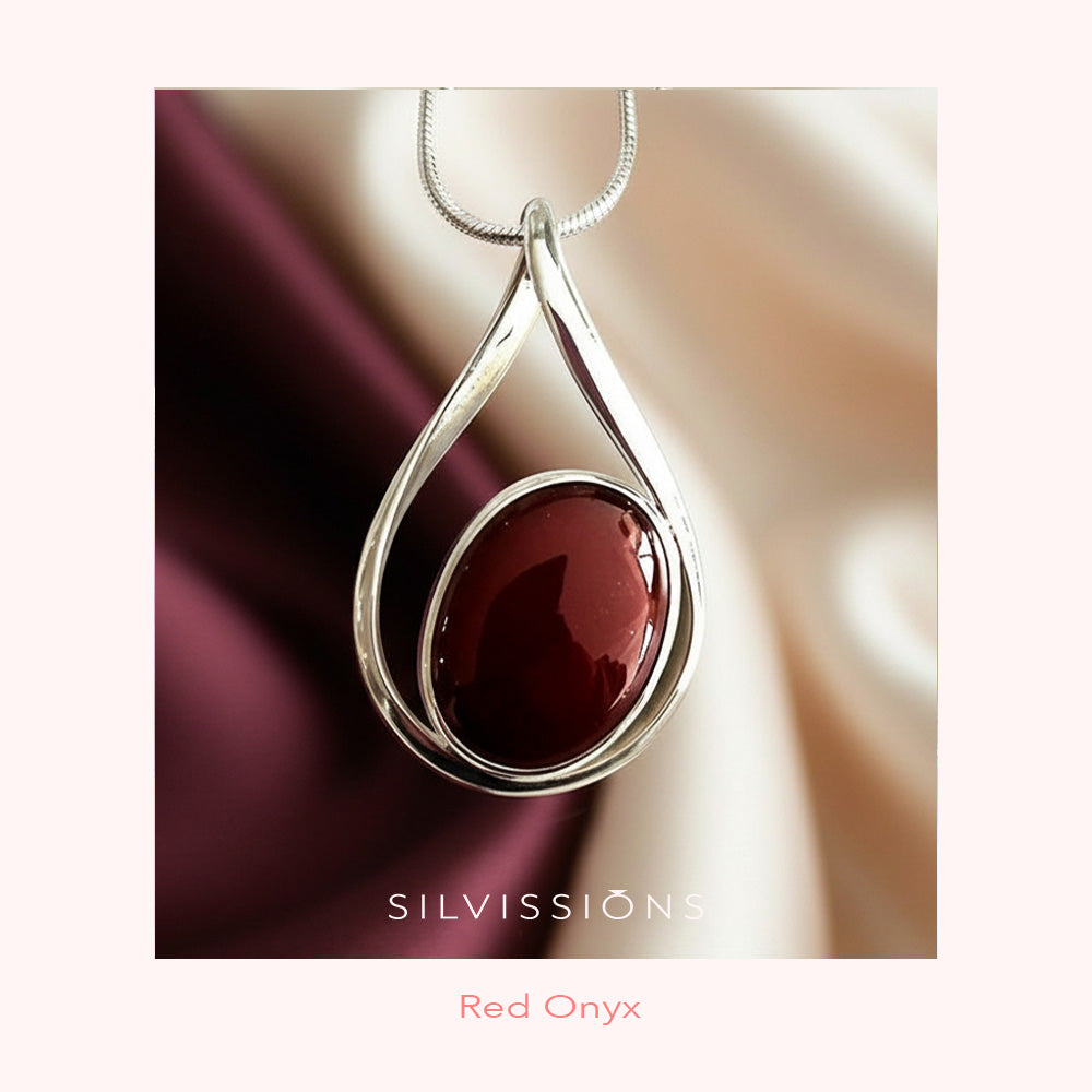 Silver pendant with red onyx stone on a satin background, featuring the Silvissions brand.