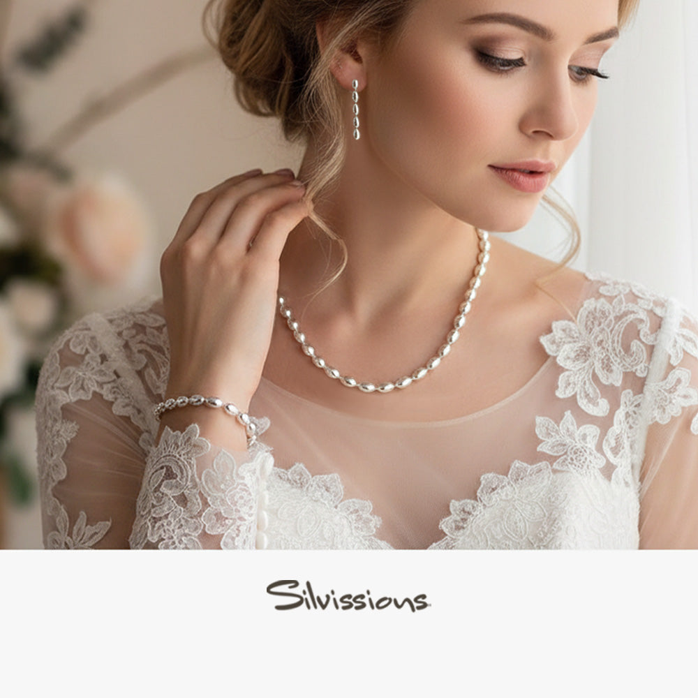 Woman wearing a sterling silver beaded necklace, bracelet and earrings with 'Silvissions' branding.